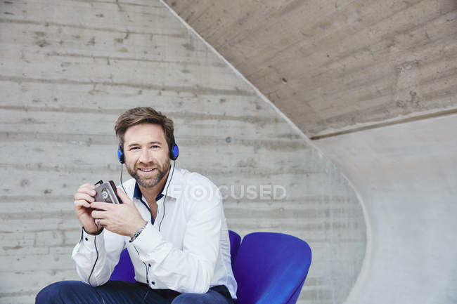 Чоловік сидить на стільці і слухає музику — стокове фото
