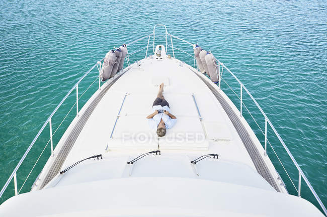 Uomo sdraiato sul ponte di yacht — Foto stock