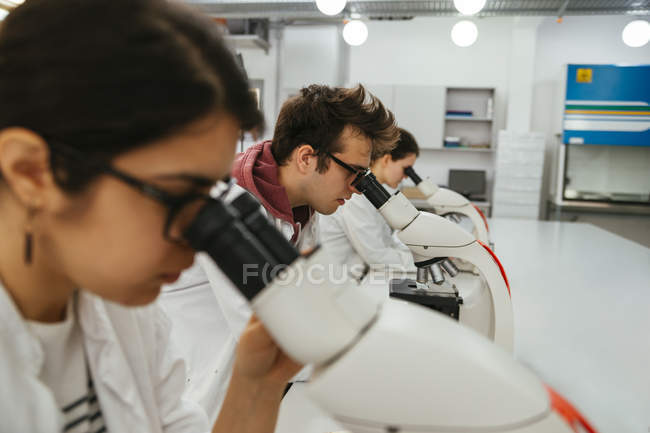 Technicians using microscopes in lab — Stock Photo