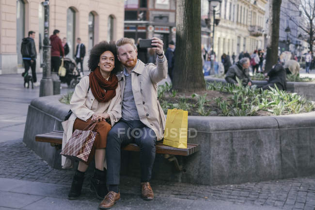Couple taking selfie on bench — Stock Photo