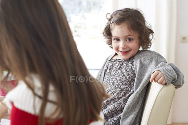 Petite fille assise sur une chaise — Photo de stock