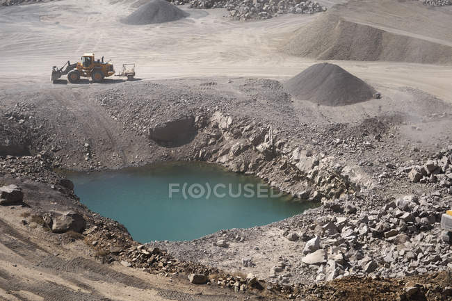 Water hole at a quarry and digger — Stock Photo