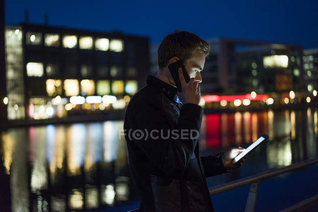 Man using phone and tablet — Stock Photo
