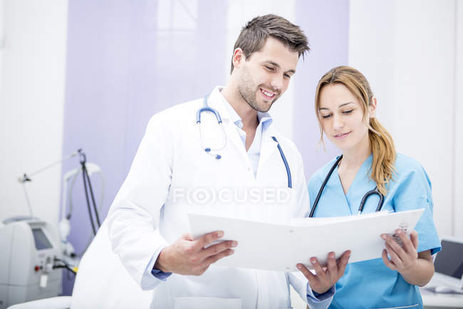 Zwei lächelnde Ärzte halten Ordner in der Hand — Stockfoto