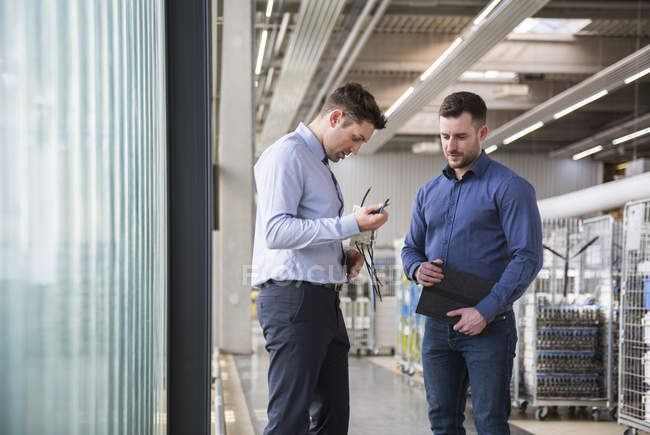 Männer untersuchen Produkt in Fabrik — Stockfoto