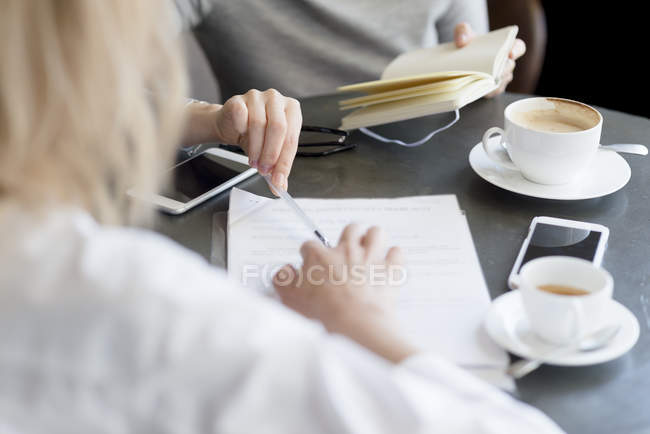 Women with documents and cellphones — Stock Photo