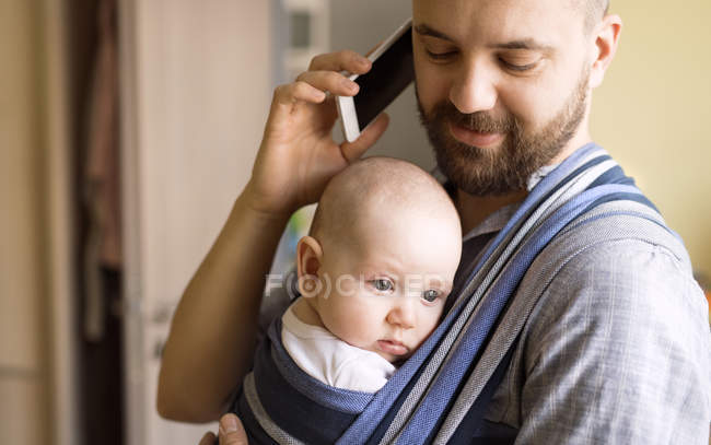 Padre con hijo pequeño hablando por teléfono - foto de stock