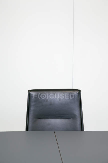Leather chair behind table top — Stock Photo