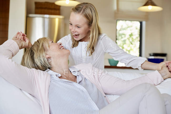 Chica divirtiéndose con la abuela en casa - foto de stock