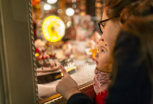 Girls looking at Christmas shop window — Stock Photo