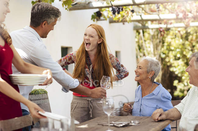 Happy family setting table outside for lunch — Stock Photo