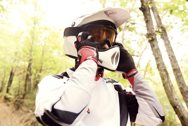 Motocross motero celebración máscara en el bosque - foto de stock