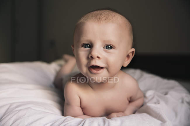 Baby boy lying on bed — Stock Photo