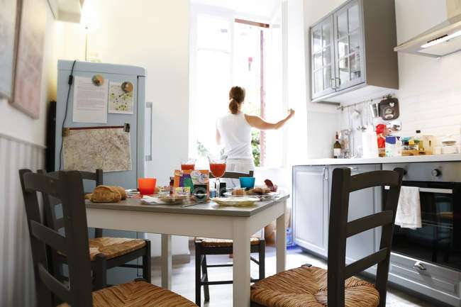 Donna apertura finestra della cucina — Foto stock