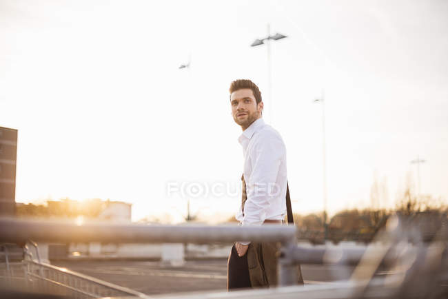 Young businessman standing in street — Stock Photo