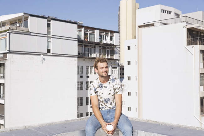 Людина, що сидить на терасу на даху з кави — стокове фото