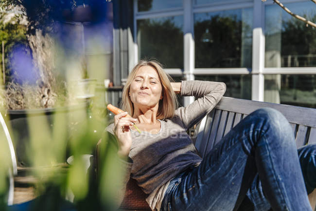 Mulher relaxante no banco de jardim — Fotografia de Stock