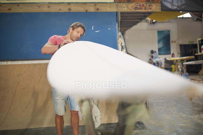 Hombre chequeando tabla de surf - foto de stock