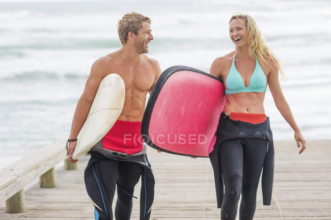 Couple walking with surfboards — Stock Photo
