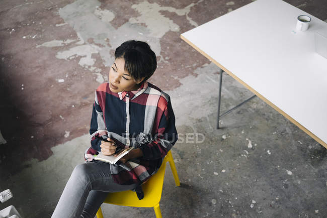 Femme assise sur une chaise avec ordinateur portable — Photo de stock