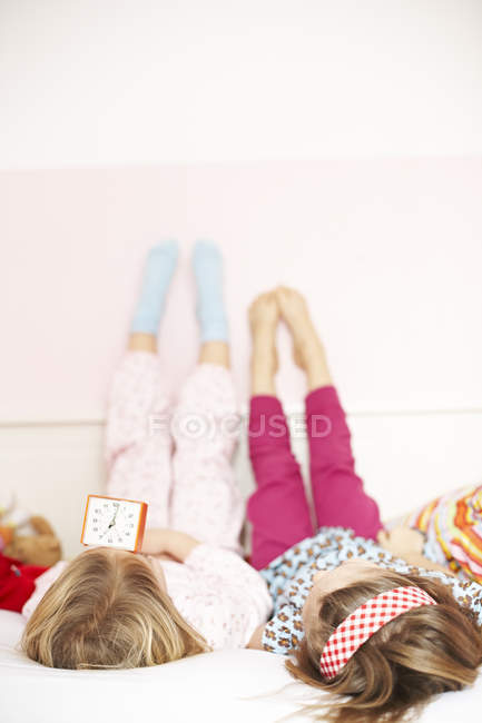 Girls lying on bed — Stock Photo