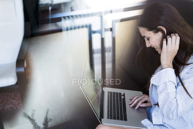 Mujer joven usando el ordenador portátil - foto de stock