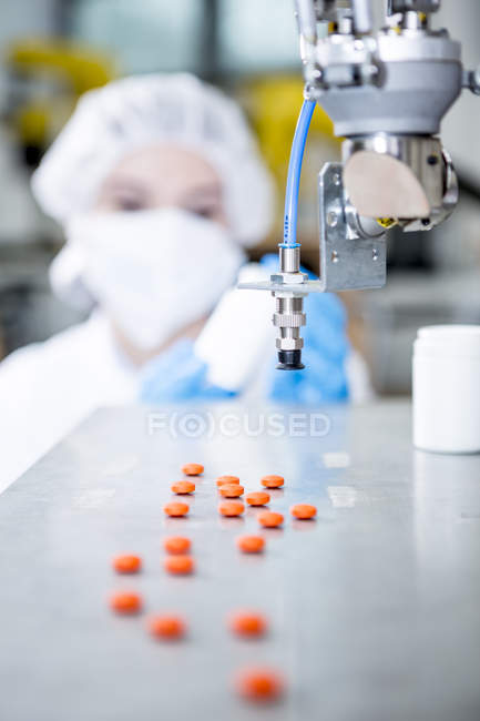 Робот обрабатывает таблетки с женщиной в фоновом режиме — стоковое фото