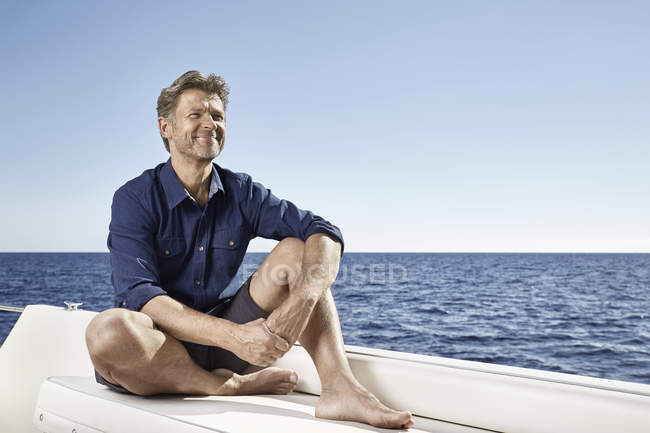 Uomo seduto su yacht a motore — Foto stock