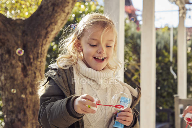 Girl making soap bubbles — Stock Photo