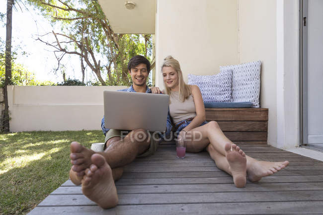 Casal sentado no terraço e usando laptop — Fotografia de Stock