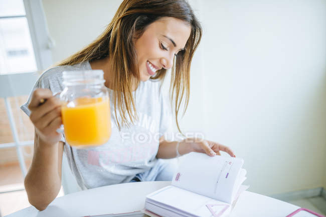 Жінка з склянку соку, дивлячись на ноутбук — стокове фото