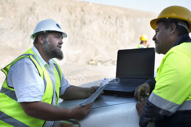 Workers at quarry discussing — Stock Photo