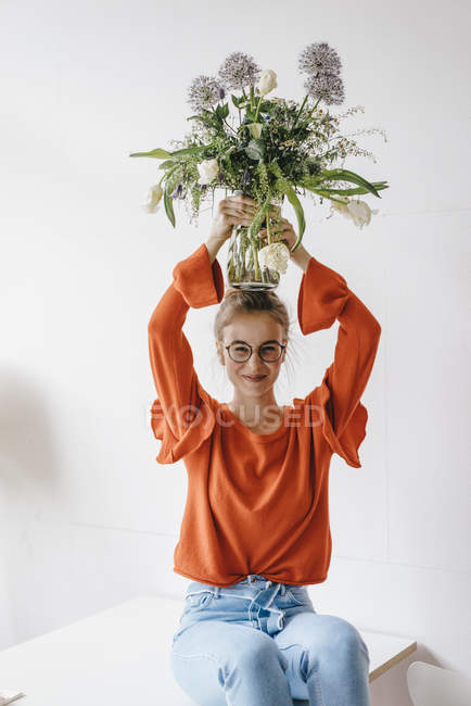 Donna che tiene vaso di fiori sulla testa — Foto stock