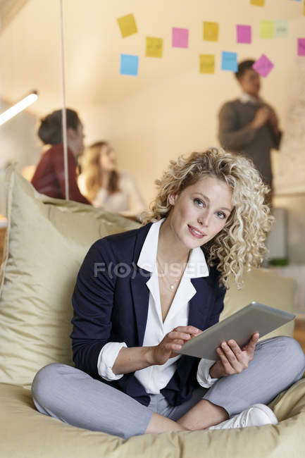 Женщина в офисе с помощью планшета — стоковое фото