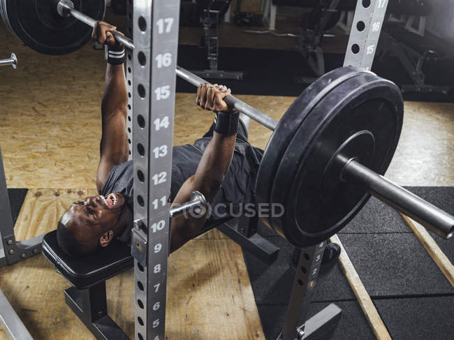 Atleta in palestra che fa sollevamento pesi — Foto stock