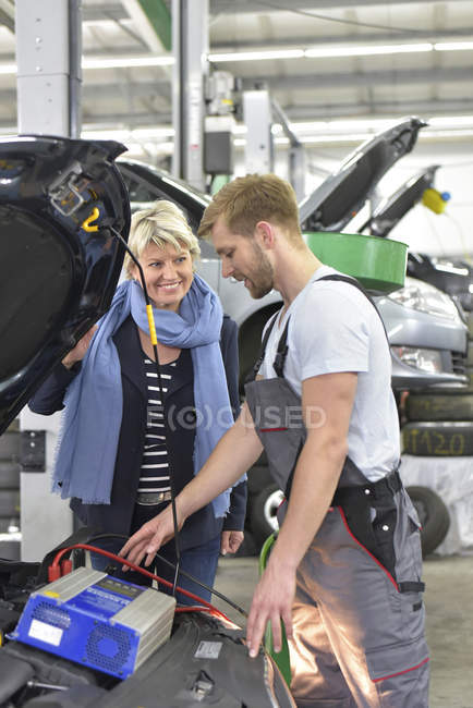 Mécanicien de voiture debout avec le client — Photo de stock