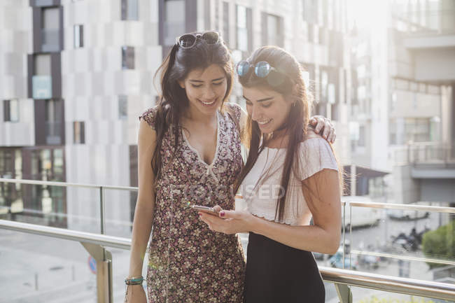 Women using cell phone in city — Stock Photo