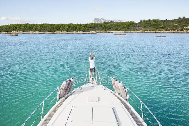 Uomo in piedi a yacht scattare foto — Foto stock