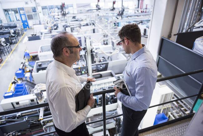 Two men talking in factory — Stock Photo