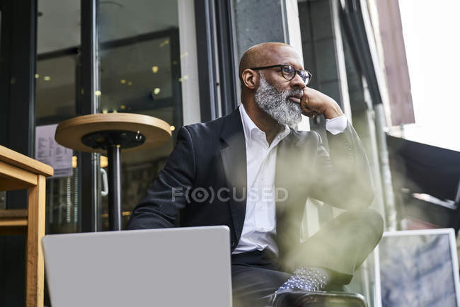 Geschäftsmann sitzt mit Laptop im Café — Stockfoto