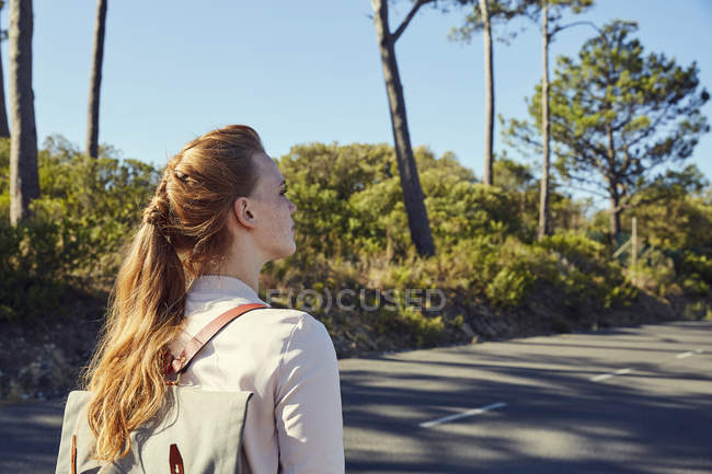 Mujer con mochila en la carretera - foto de stock