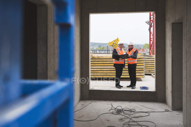 Hommes interagissant dans le bâtiment en construction — Photo de stock