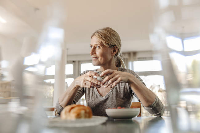 Женщина завтракает дома — стоковое фото