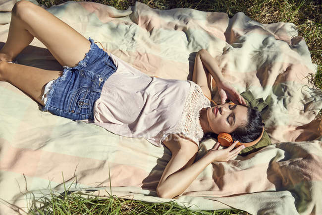 Donna su coperta ascoltare musica — Foto stock