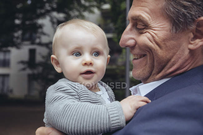 Businessman holding baby boy — Stock Photo