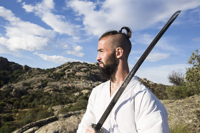 Чоловік тримає katana меч на відкритому повітрі — стокове фото