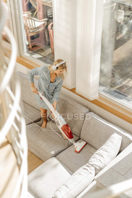 Donna Hoovering divano — Foto stock