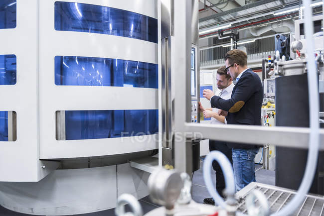 Zwei Männer unterhalten sich in Fabrik — Stockfoto