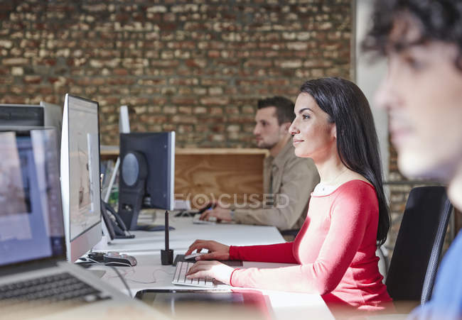 Woman working in office with colleagues — Stock Photo
