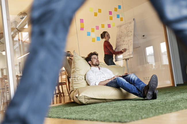 Man in office sitting in bean bag — Stock Photo
